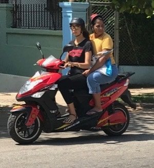 scooter riders wearing silly little helmets