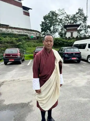 Photo of our guide, Tshetem, wearing traditional Bhutanese dress.