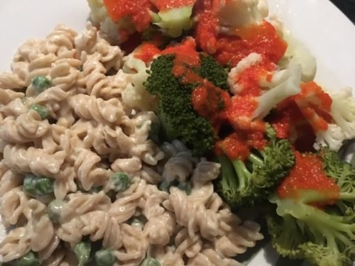 Vegan alfredo and veggies with red pepper sauce